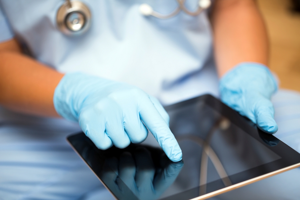 Doctor with gloves using Ipad